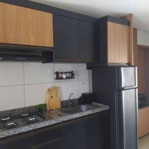 路易斯科雷亚Condomínio Villamares的厨房配有黑色橱柜和不锈钢冰箱