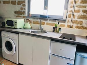 UsCocooning little house in french Vexin的厨房配有水槽和微波炉