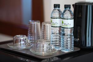 邦涛海滩Hill Myna Holiday Park & Cafe的桌子上装有水瓶和玻璃杯的托盘
