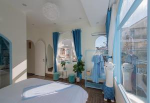 大叻Moc Thach Blue House DaLat的一间卧室配有蓝色窗帘、一张床和窗户