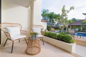 邦涛海滩Hill Myna Holiday Park & Cafe的一个带两把椅子和一张桌子的庭院和一个游泳池