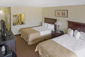 威奇托Economy Hotel Plus Wichita的酒店客房设有两张床和电视。
