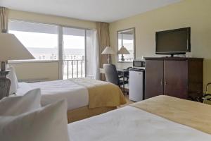 威奇托Economy Hotel Plus Wichita的酒店客房设有两张床和一台平面电视。