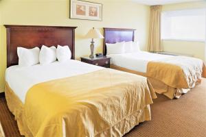 威奇托Economy Hotel Plus Wichita的酒店客房设有两张床和窗户。