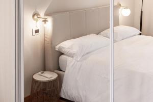米兰Montello Livings, Exclusive terrace and skyline view的一间卧室设有两张床和玻璃墙