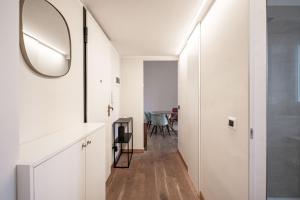 米兰Montello Livings, Exclusive terrace and skyline view的白色走廊,配有镜子和桌子
