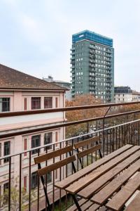 米兰Montello Livings, Exclusive terrace and skyline view的阳台顶部的木凳