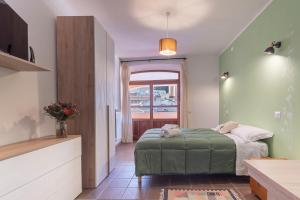 拉努塞伊Locanda Sighimi的一间卧室设有一张绿色的床和一个窗户。
