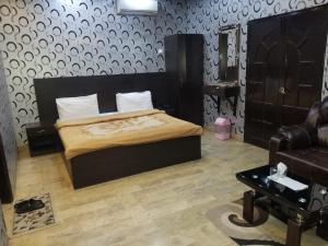 卡拉奇Karachi Guest House & Couple Hotel的一间卧室配有一张床、一把椅子和一张沙发