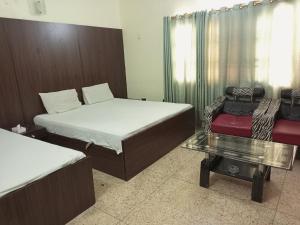 卡拉奇Karachi Guest House & Couple Hotel的带两张床和玻璃桌的房间