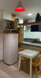 维多利亚Apartamento bairro Praia do Canto na Reta da Penha的厨房配有冰箱和桌椅