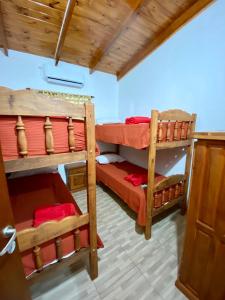 Puerto EsperanzaCabañas Aranderay的客房设有2张双层床和红色床单