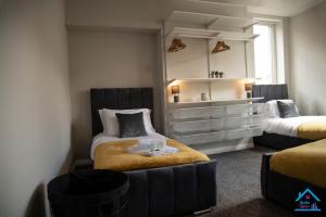 盖茨黑德Spacious and Homely 3 Bedroom Flat - SuiteLivin的一间卧室配有两张床和梳妆台。