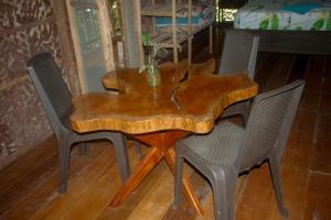 莱蒂西亚Hospedaje SELVA DE AVES的一张木制餐桌,四周摆放着四把椅子