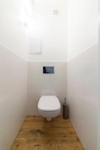 比得哥什Apartament Gersona 4的白色浴室内的白色卫生间,铺有木地板