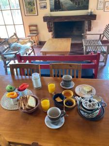 科洛尼亚卡洛斯佩莱格里尼Posada Che Teindy的一张木桌,上面摆放着早餐食品和咖啡