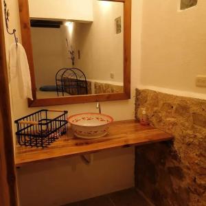 Santa ElenaHotel Colibrí Petén的浴室设有镜子和木架上的碗