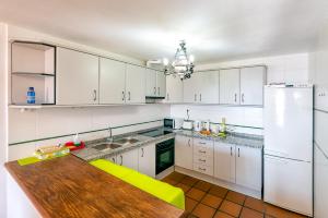 卡皮雷拉Apartamento Casa Manuela en Capileira - Alpujarra的厨房配有白色橱柜和木桌