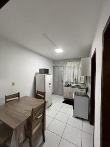 弗洛里亚诺波利斯Apartamento na Praia dos Ingleses的厨房配有桌子和冰箱
