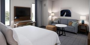 辛辛那提Staybridge Suites - Cincinnati East - Milford, an IHG Hotel的酒店客房配有床、沙发和电视。