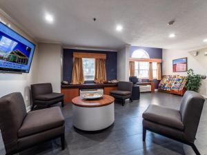 奥卡拉奥卡拉米克罗套房酒店的一间设有椅子和桌子的等候室以及一台电视