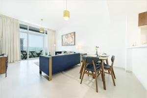 迪拜Maison Privee - Superb 1BR apartment overlooking Zabeel Park and Dubai Frame的用餐室以及带桌椅的起居室。