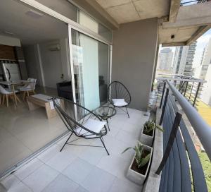 布宜诺斯艾利斯Apartamento 2 Ambientes - Moderno totalmente Amoblado的大楼内的阳台配有两把椅子和一张桌子