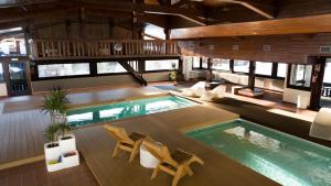 瓦尔迪佐多Hotel Valgranda Wellness & Spa的一座带椅子和桌子的室内泳池