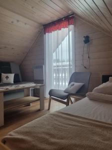 科尼基Domki na Zagroniu的一间卧室配有一张床、一张书桌和一个窗户。