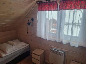 科尼基Domki na Zagroniu的小房间设有床和窗户