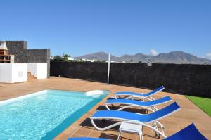 普拉亚布兰卡Villa Esmeralda的一个带两把椅子的游泳池和一个游泳池