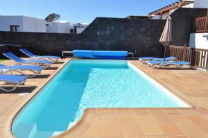 普拉亚布兰卡Villa Esmeralda的一个带躺椅的游泳池和一个游泳池