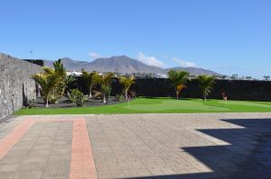 普拉亚布兰卡Villa Esmeralda的一座种植了棕榈树和石墙的高尔夫球场
