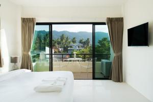 邦涛海滩Hill Myna Holiday Park & Cafe的一间卧室设有一张床,享有阳台的景色