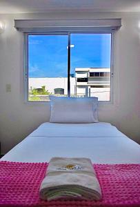 圣玛尔塔Hotel Parque de los Novios Inn的一间卧室设有一张大床和大窗户