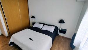 马德普拉塔Confortmdp apartamentos的卧室配有白色的床和2个枕头