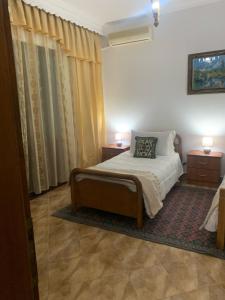 培拉特Vila Demaj的一间卧室配有一张带2个床头柜和2盏灯的床。