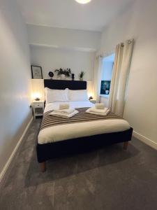 邓弗里斯Modern Town-Centre Apartment的一间卧室配有一张大床和两条毛巾