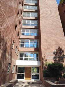 马德普拉塔Confortmdp apartamentos的前面有一扇门的高高的砖砌建筑