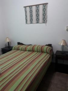 梅洛La Loma Resort的一间卧室配有一张带两盏灯的床和一扇窗户。