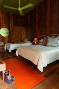 托尔图格罗Mawamba Lodge的一间带两张床的卧室和红色地毯