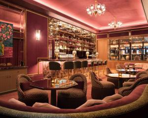 纽约Hotel Barrière Fouquet's New York的一间带桌椅的餐厅和一间酒吧