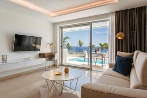 波多黎各Grand Horizon Luxury Boutique Apartments的带沙发、电视和桌子的客厅