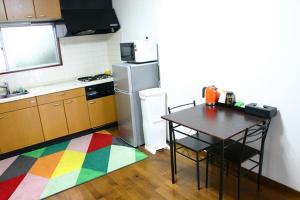 阿扎格瓦RETRO retro - Vacation STAY 03865v的厨房配有桌子和色彩缤纷的地毯
