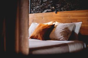 瓦隆古Porto Natura Loft的一张带白色枕头和木制床头板的床