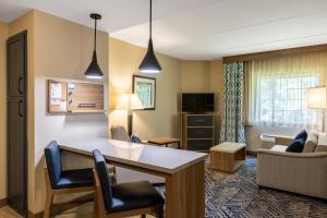 布拉夫顿布拉夫顿-希尔顿黑德烛木套房酒店的酒店客房设有桌椅和客厅。
