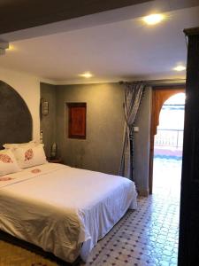 马拉喀什riad rose eternelle的卧室设有一张白色大床和一扇窗户。