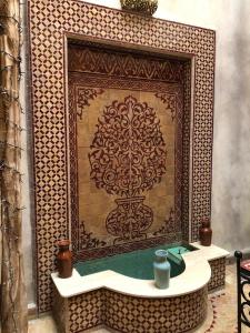 马拉喀什riad rose eternelle的壁炉前带水槽的瓷砖墙