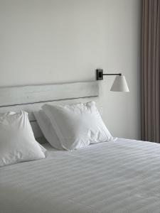 CavaleiroCasa da Courela的白色的床、白色枕头和灯