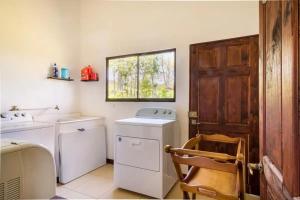 图里亚尔瓦Rancho Bellavista, Unique views, Pool and WiFI!的洗衣房配有洗衣机和烘干机以及窗户。